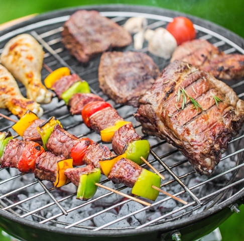 Meat and vegetables cooking on a charcoal grill