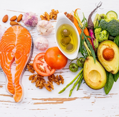Image of anti-cancer foods including salmon, tomato, olive oil, avocado, broccoli, nuts, asparagus